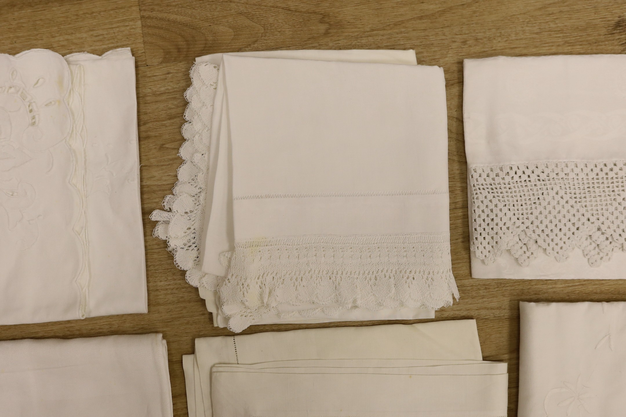 A quantity of lace trimmed and embroidered fabrics including tray cloths and pillow cases